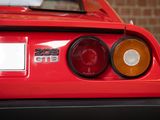 the rear end of a red sports car parked in front of a brick wall