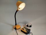 une lampe posée sur une table à côté d'un téléphone portable