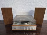 a close up of a record player and speakers on a wooden table