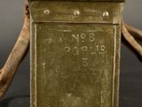 an old metal box with a wooden handle sitting on top of a table