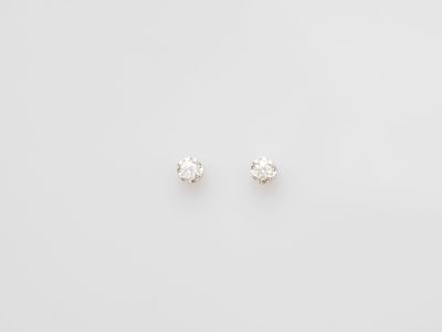 a pair of diamond stud earrings on a white background