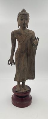 statue of a standing buddha on a wooden base on a white background