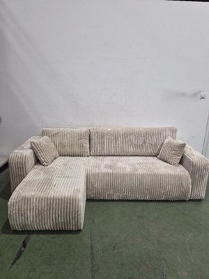 un canapé et un pouf dans une pièce avec une moquette verte