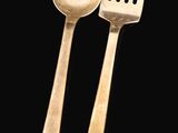 two silver spoons and a fork on a black background