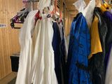 a lot of dresses hanging on a rack in a room
