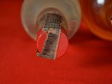 a close up of a bottle of alcohol on a red surface