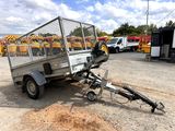 a trailer with a cage on the back of it in a parking lot