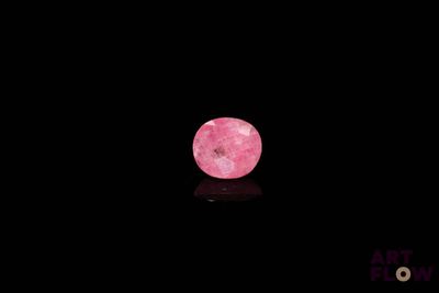 une image représentant une pomme rose posée sur une surface noire