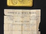 an old gold bar sitting on top of a piece of paper next to a piece of paper