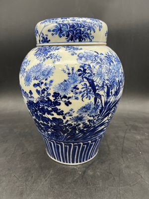 a close up of a blue and white vase on a table