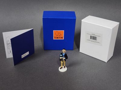 une petite figurine représentant un homme debout à côté d'une cabine téléphonique bleue