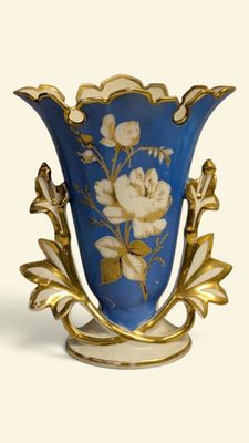 un vase bleu orné de fleurs blanches, posé sur une surface blanche