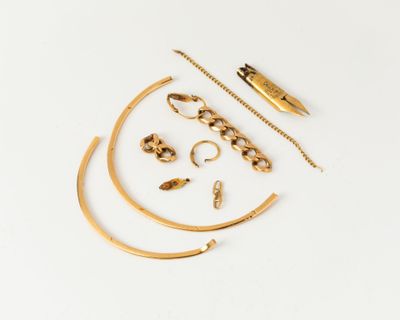 an assortment of gold jewelry on a white surface