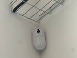 des toilettes dans une salle de bains, avec un panier métallique au-dessus