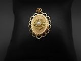 un pendentif plaqué or avec une perle au centre