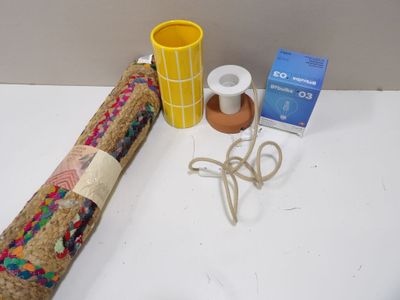a roll of fabric, a cup, and a pair of scissors on a table