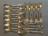 a lot of silver spoons and forks laid out on a table