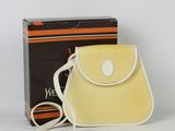 un sac à main orange et blanc posé à côté d'une boîte noire et blanche