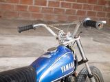 a blue and black motorcycle parked in front of a brick wall