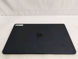 a black apple laptop sitting on a white surface