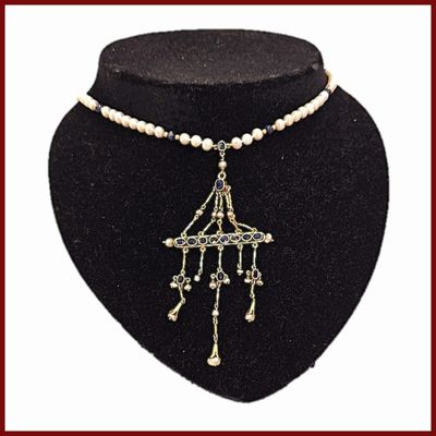 collier de perles avec un pendentif en perles et un pendentif en perles, présenté sur un mannequin noir