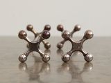 silver plated stud earrings on a table with a white wall in the background