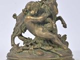 bronze statue of a ram attacking a goat on a rock