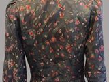 the back view of a woman ' s blouse with a floral print on it