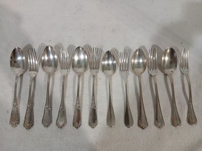 beaucoup de cuillères en argent et de cuillères à soupe sur une table
