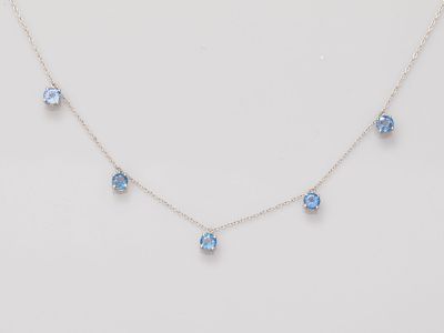 un collier avec des cristaux bleus sur fond blanc
