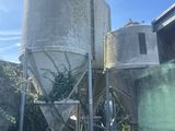 a man standing in front of two cement silos