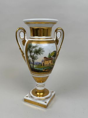 un vase avec un tableau posé sur une table