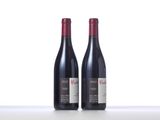 two bottles of red wine sitting on top of a table