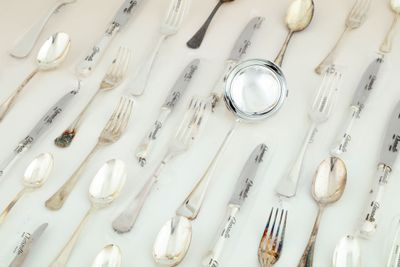 de nombreuses cuillères et fourchettes disposées sur la table