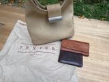 a tan purse and a brown wallet on a table
