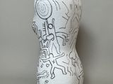 a white vase with a drawing on it sitting on a table