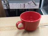 a red cup sitting on top of a cardboard box