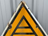 a yellow triangle sign with a black triangle on it