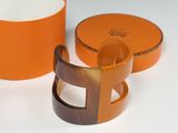 two orange bowls and a cup on a white table