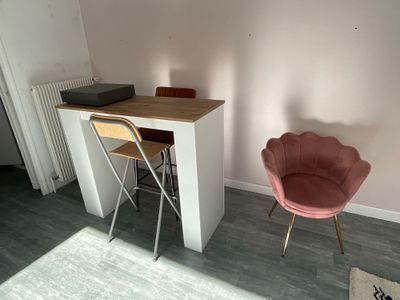 a pink chair sitting in front of a desk in a room