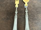 two forks and a spoon sitting on a table