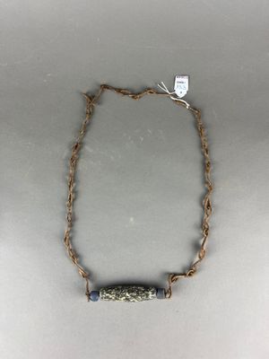 un gros plan d'un collier posé sur une table, avec une étiquette accrochée dessus