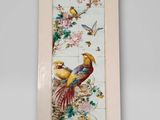 une image représentant un tableau avec des oiseaux et des fleurs accroché au mur