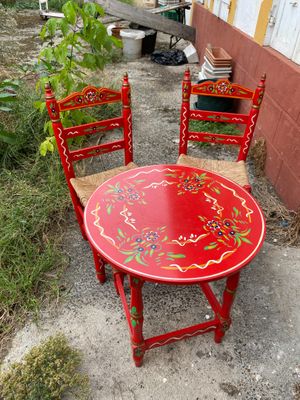 a red table and two chairs sitting on the ground