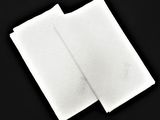two white napkins on a black surface with a black background