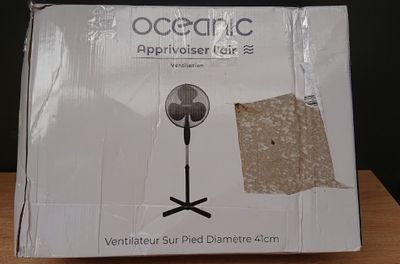 a cardboard box with a fan on it sitting on a table