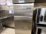 a large stainless steel refrigerator in a kitchen with a lot of counter space