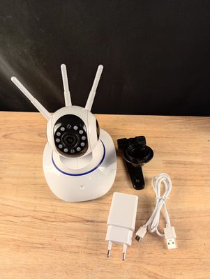 un appareil photo blanc posé sur une table en bois, à côté d'un chargeur