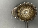 a silver spoon with a flower on top of it