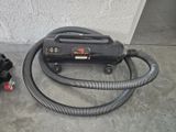 a blow dryer sitting on the floor next to a hose